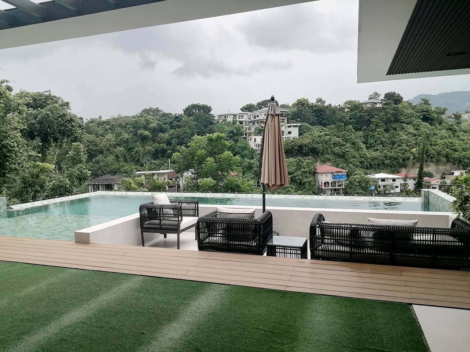 Infinity pool and covered lounge terrace overlooking a forested ravine and the hills of Cebu City